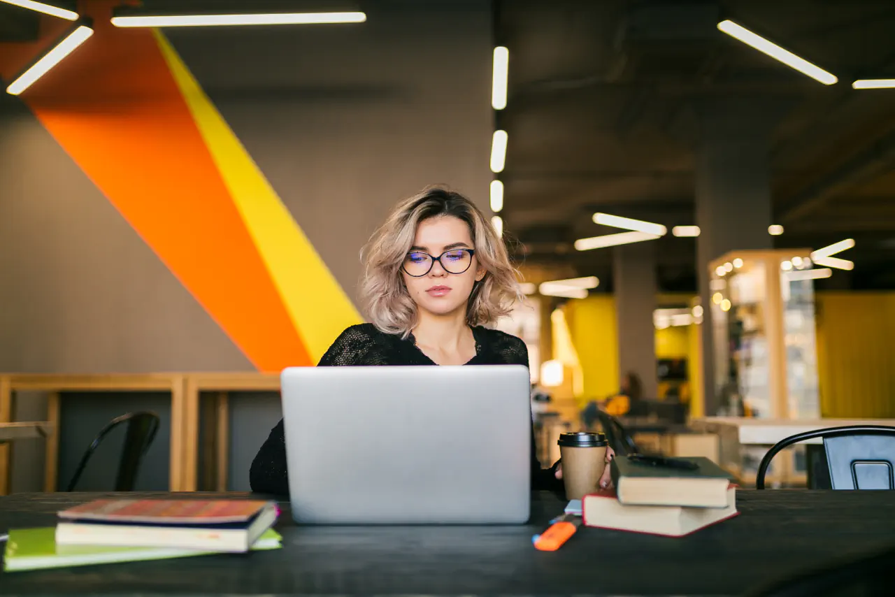 Marketing strategist working on a laptop in a coworking office